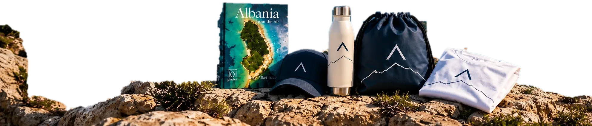 The Albania Day Kit on a rock: photography album, cap, thermal bottle, drawstring bag and T-shirt